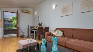 Un salon avec un canapé marron, une table basse et un coin repas comprenant des chaises et une table.