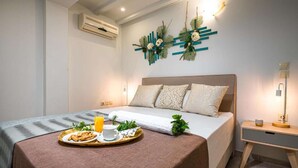 Une chambre moderne avec un lit, une table de chevet et un plateau contenant des éléments pour le petit-déjeuner.
