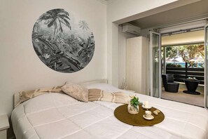 Una camera da letto con un letto grande, un murale tropicale e vista sull'esterno.