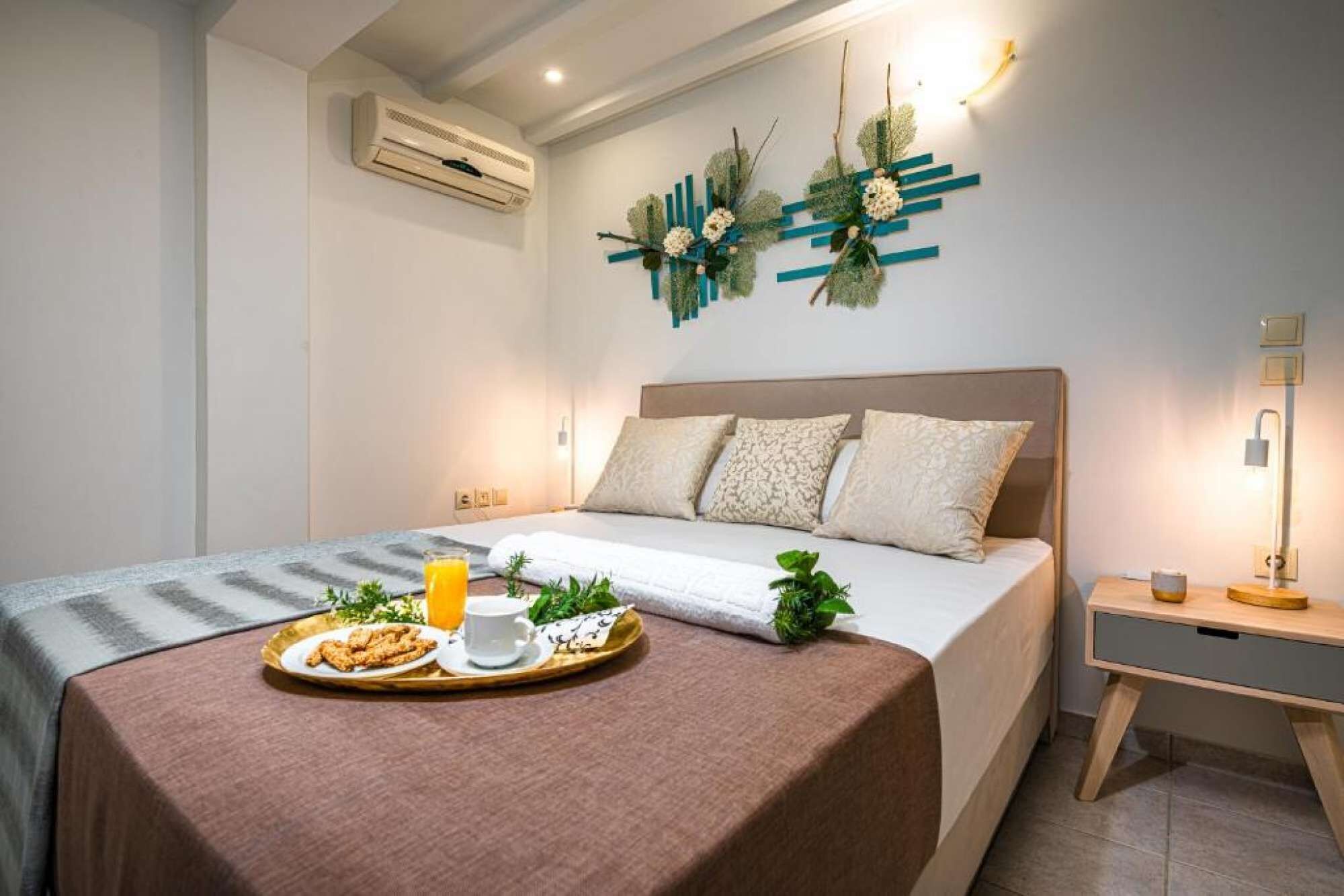 A modern bedroom with a bed, bedside table, and a tray with breakfast items.