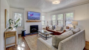 Ein Wohnzimmer mit Kamin, Fernseher und einer Couch.