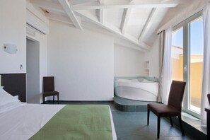 A hotel room with a bed, two chairs, a bathtub, and a large window. - Hotel La Riva (Rome)
