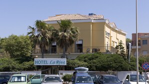 Un edificio giallo con un cartello che riporta la scritta "HOTEL La Riva".