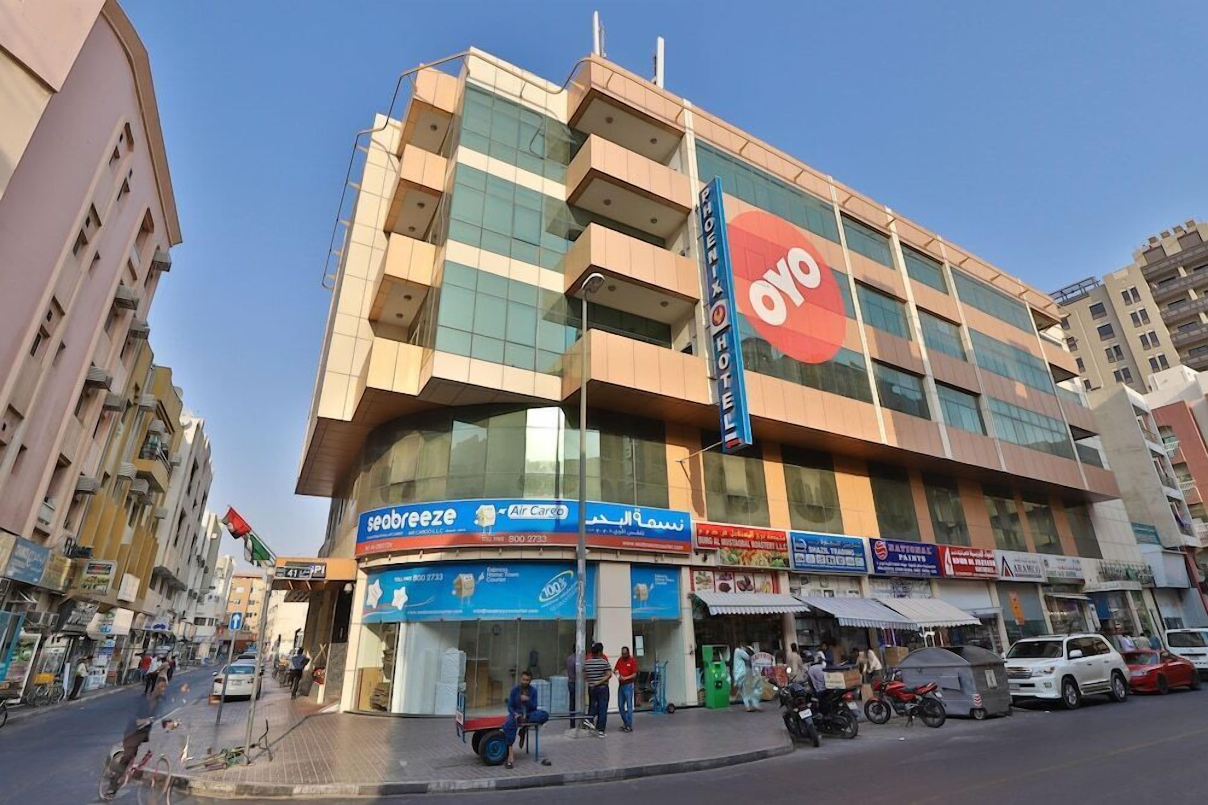 A hotel with a prominent 'OYO' sign, a visible 'Seabreeze Air Cargo' shop, and a 'National Paints' store.