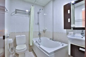 A bathroom with a toilet, bathtub, shower, and sink. - Phoenix Hotel Deira (Dubai)