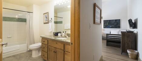 A bathroom with a shower, toilet, and vanity.