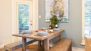 A dining area with a wooden table, benches, and a decorative wall piece. - Sprawling Corner Condo, Amazing 1st floor deck, Ski in/out, Sleeps 4 (Whistler)