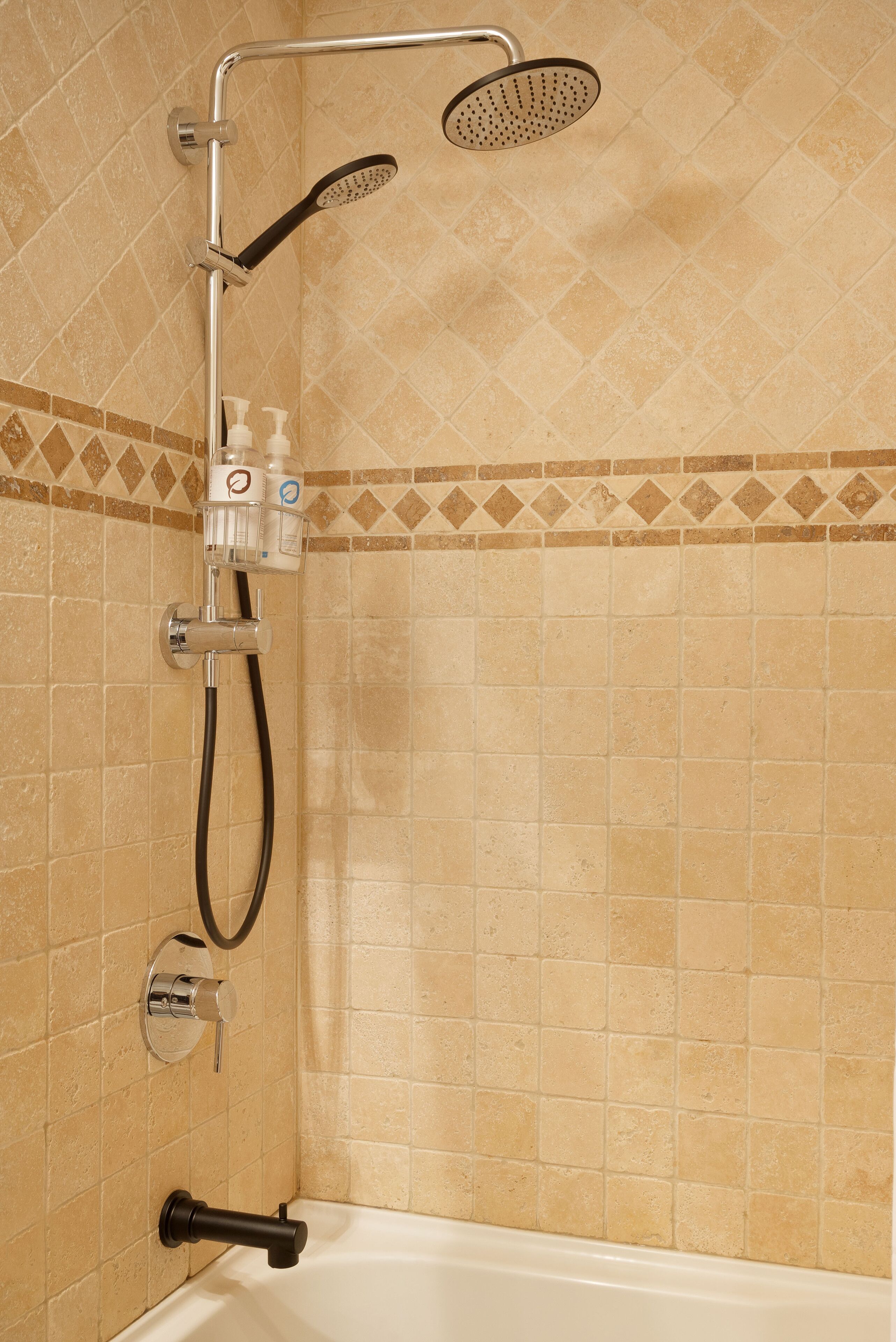 A shower with a handheld showerhead and a handheld hose.