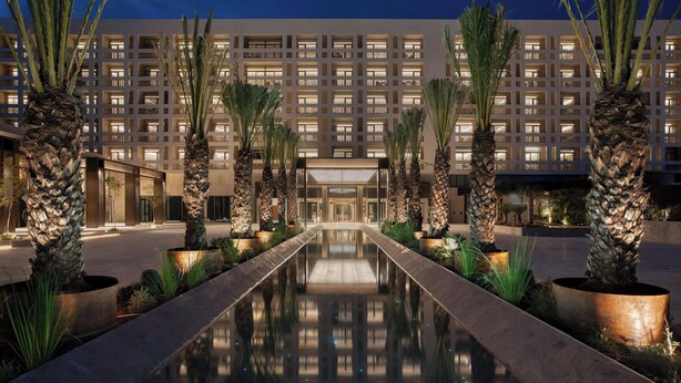 A hotel with a reflective pool, palm trees, and a modern building facade. - The Landmark Nicosia, Autograph Collection (Nicosia)
