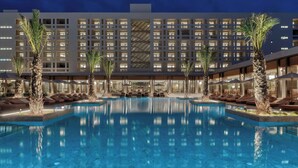 A hotel with a large outdoor pool, palm trees, and a modern building facade. - The Landmark Nicosia, Autograph Collection (Nicosia)