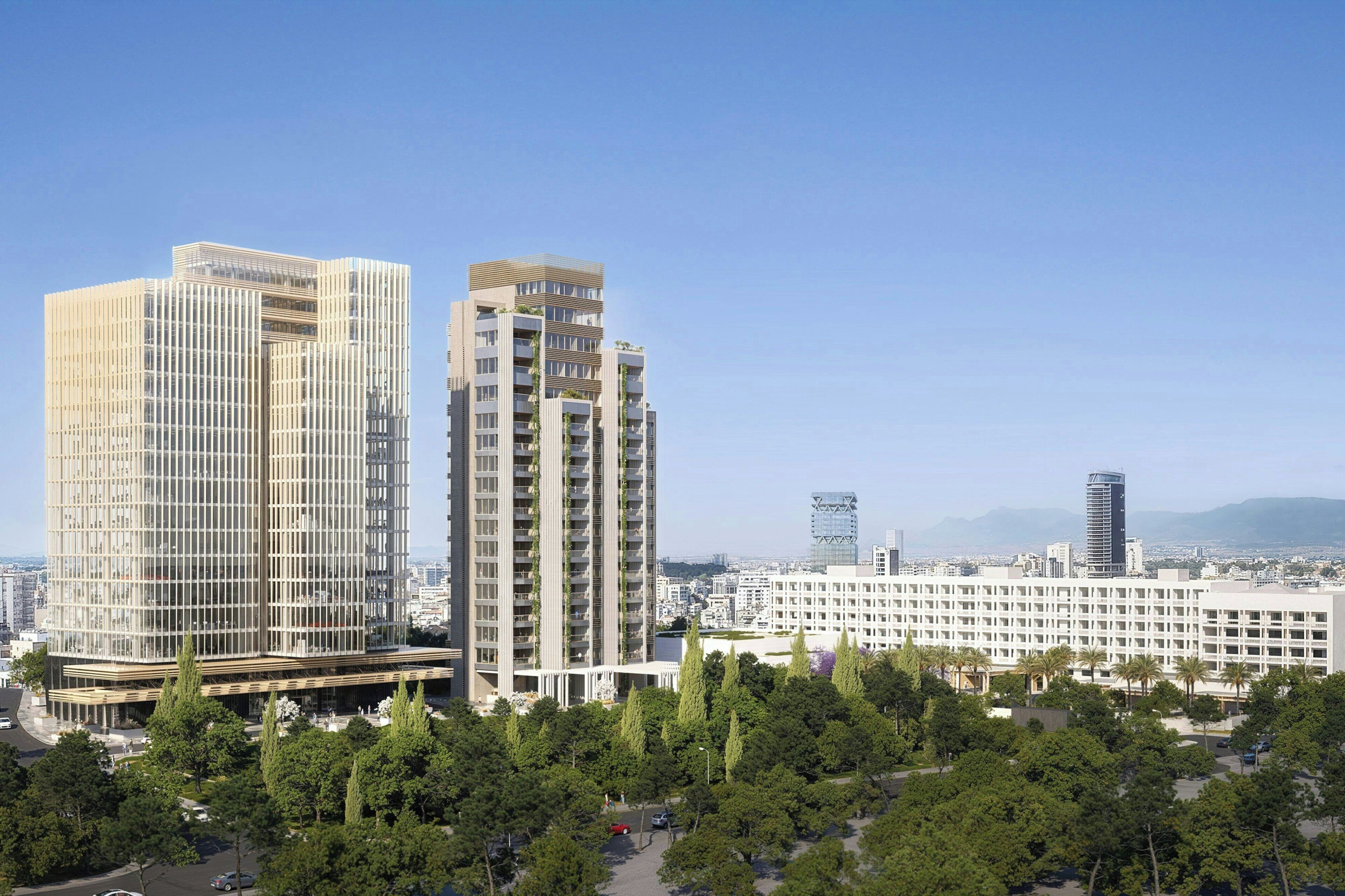 A modern high-rise building with a glass facade, surrounded by a park with trees and a parking area.