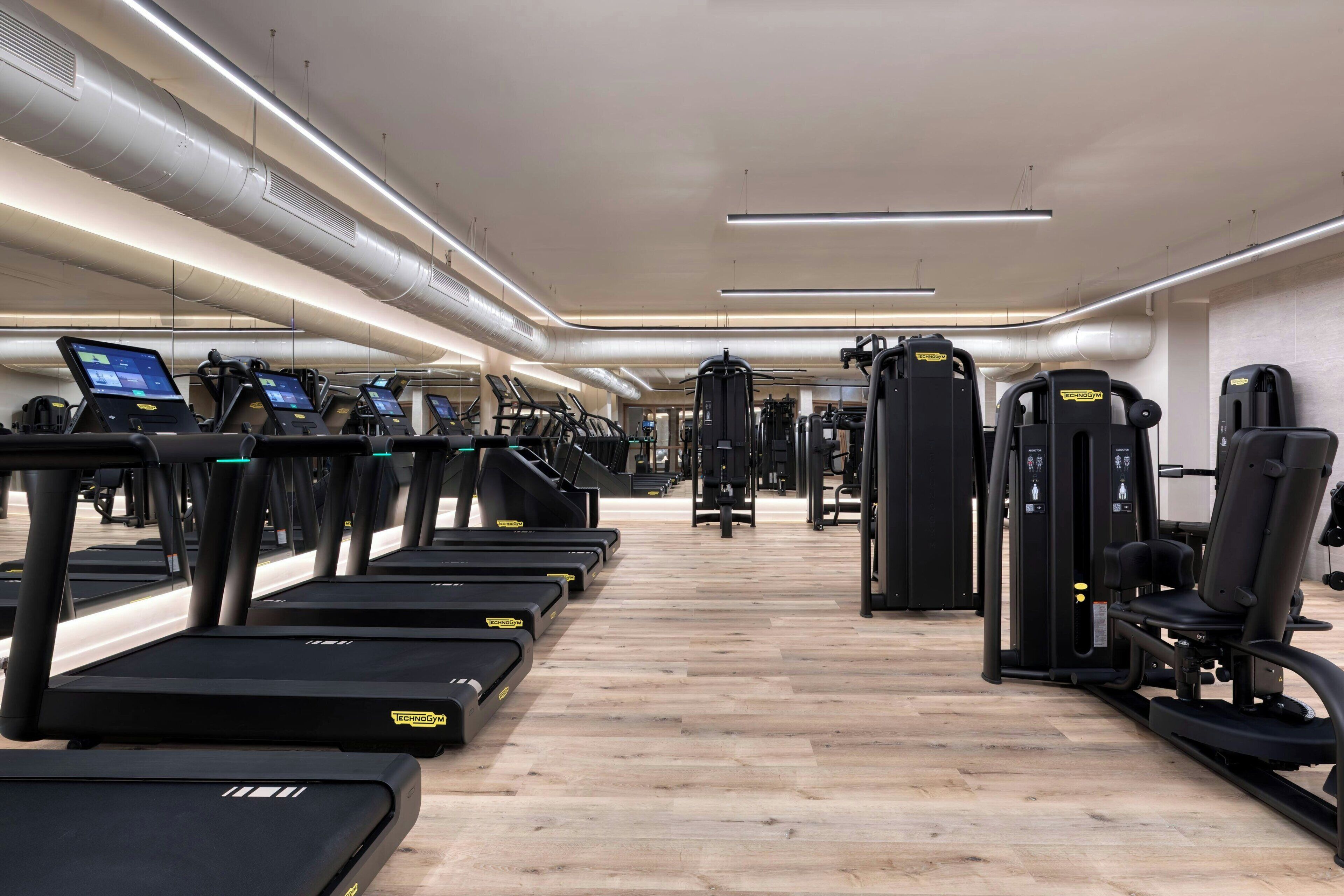 A gym with treadmills, weight machines, and exercise equipment.