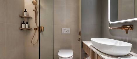 A modern bathroom with a shower, toilet, and vanity with a large sink.