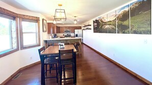 Una cucina moderna con mobili in legno, un'isola centrale e un'area pranzo con tavolo e sedie in legno.