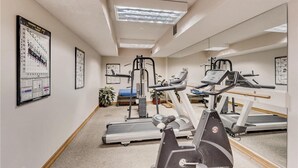 Un centre de remise en forme équipé de tapis de course, d’un appareil elliptique et d’une machine de musculation.