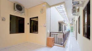 A corridor with tiled flooring, a wooden bench, and a ceiling fan. - OYO 90037 Rumah Verde (Bogor)