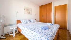 Une chambre à coucher avec un lit, une armoire en bois et un radiateur.