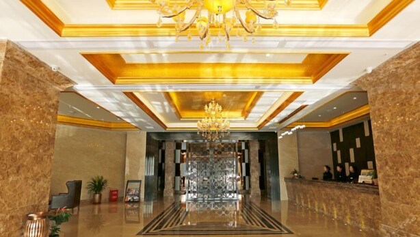 A spacious lobby with a grand chandelier, marble flooring, and a reception desk. - Caifu Holiday Hotel (Chongqing)
