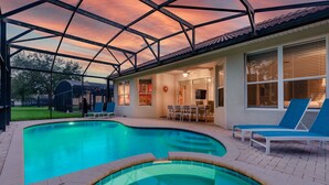 Una piscina con una estructura de techo geométrica, un patio cubierto y una zona de comedor.