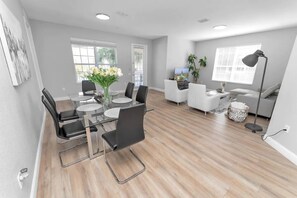 Relax in this stylish living space with a glass dining table, comfortable seating, and a cozy sofa.