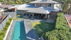A modern house with a swimming pool, a covered patio, and a well-maintained garden. - 6A Blair St - Echuca Holiday Homes (Moama)