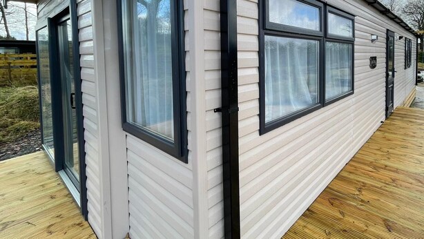 Una casa móvil de un piso con ventanas amplias y un porche cubierto.