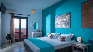A modern hotel room with a large bed, a desk, a chair, and a view of the sea. - Anemos Inn Adults Only By Estia (Hersonissos)