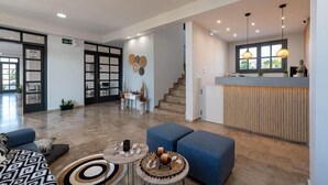 A spacious lobby with a reception desk, seating area, and a staircase leading to upper floors. - Anemos Inn Adults Only By Estia (Hersonissos)