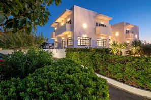 A modern two-story building with large windows and a well-maintained garden in front. - Anemos Inn Adults Only By Estia (Hersonissos)