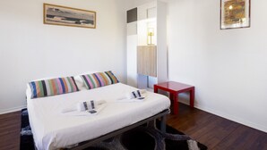 Ein Hotelzimmer mit einem Bett, einem kleinen Tisch, einem Spiegel und einem Bild an der Wand.