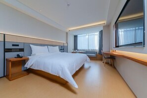 A modern hotel room with a large bed, bedside tables, a desk, and a window with curtains. - Ji Hotel (Shenzhen)