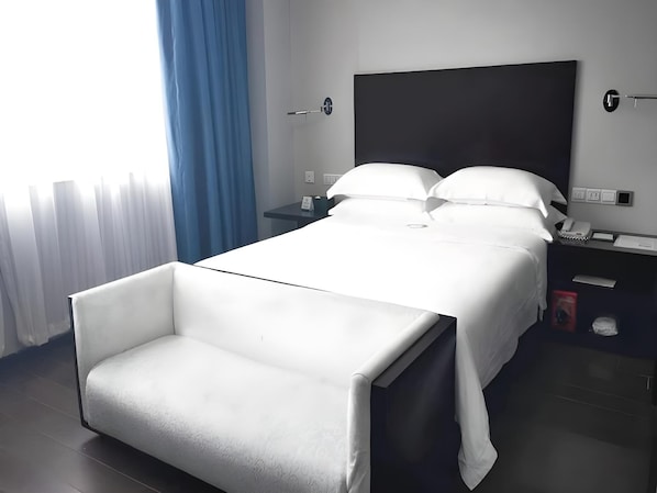A modern hotel room with a bed, bedside tables, a chair, and a large window with curtains. - Guangdong Nanmei Osotto Hotel (Guangzhou)