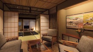 Ein traditioneller japanischer Raum mit Tatami-Böden, niedrigem Holzmobiliar und verschiebbaren Türen.