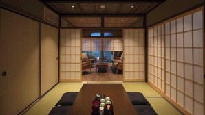 Ein traditioneller japanischer Raum mit Tatami-Böden, Shoji-Schirmen, einem niedrigen Tisch mit einer Tablett voller Gegenstände und Blick durch die Schirme.