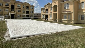 A residential complex with multiple two-story buildings, a volleyball court, and a well-maintained lawn. - Stunning Stay Disney Orlando, 2Bed / 2Bath Condo (Davenport)