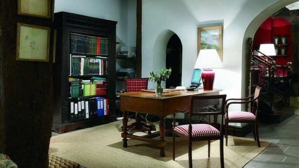 A study room with a wooden desk, chairs, a bookshelf, and a lamp. - Churrut Hotel (Vera de Bidasoa)