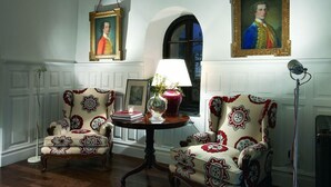 A room with two patterned armchairs, a small table with a lamp, and two framed portraits on the wall. - Churrut Hotel (Vera de Bidasoa)