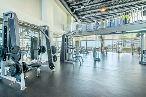 A gym with weightlifting equipment, a mezzanine level, and large windows. - Beach view with a large private balcony. (Panama City Beach)
