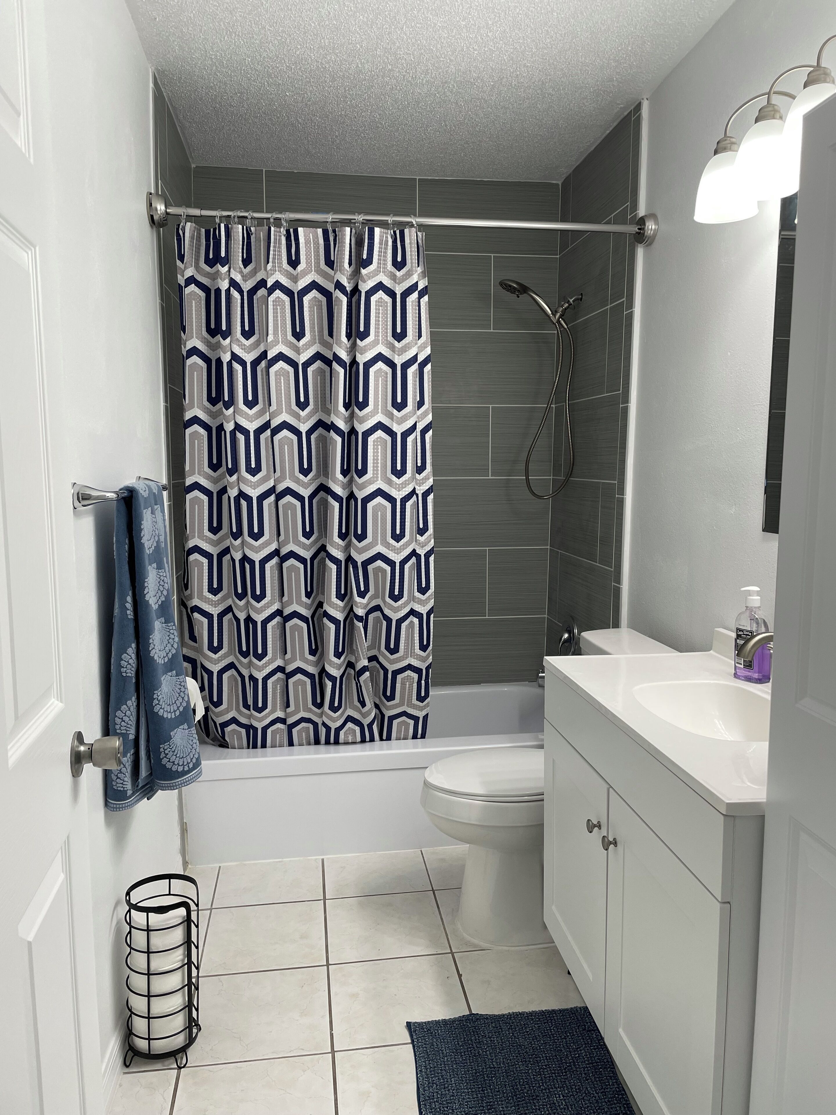 Ein Badezimmer mit Duschvorhang, Toilette, Waschbecken und Handtuchhalter.