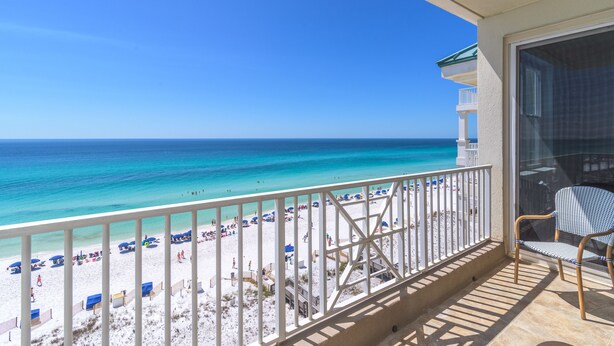 A balcony with a view of a beach and ocean.