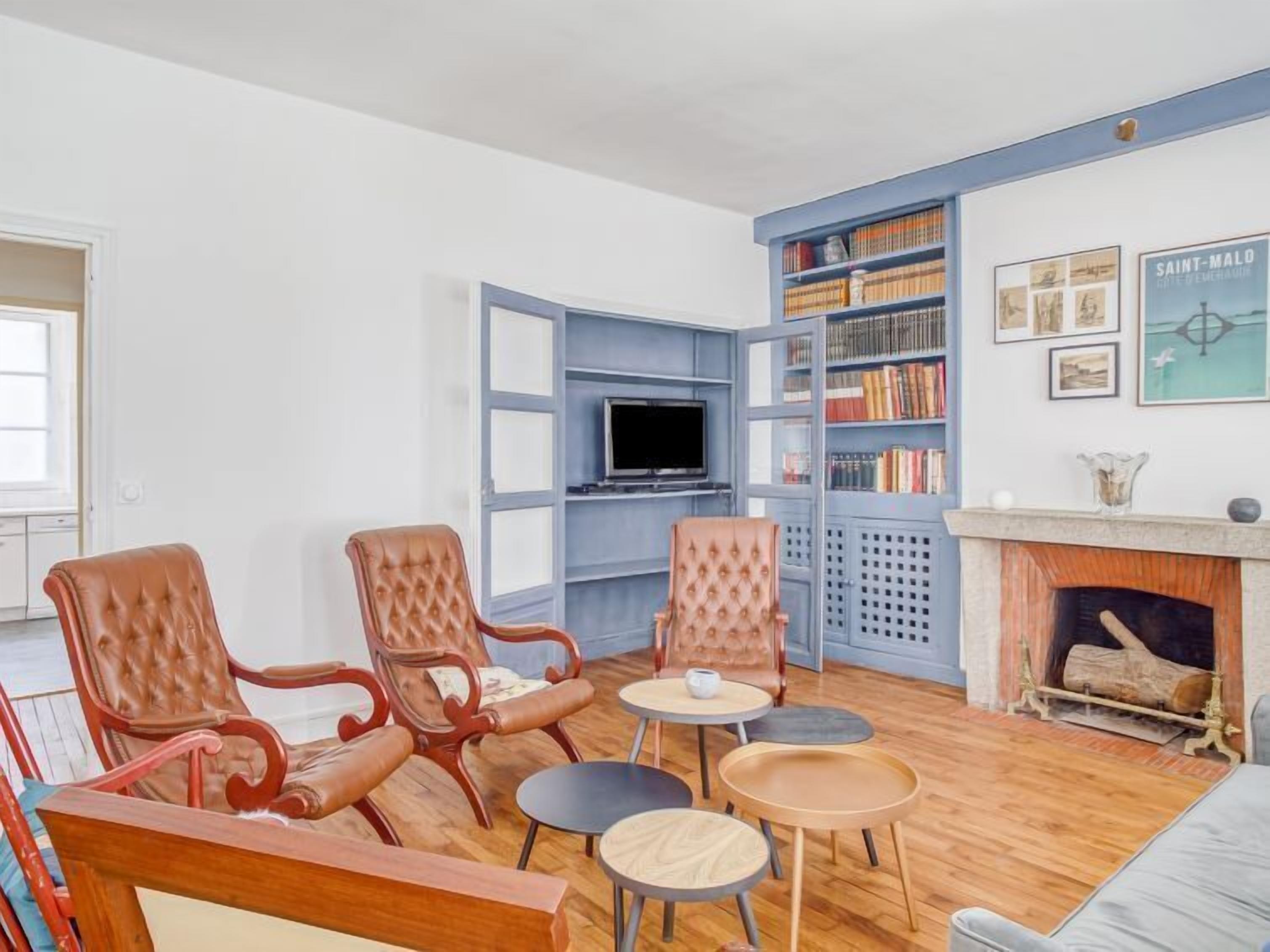 Ein Wohnzimmer mit Kamin, Fernseher und Bücherregal.