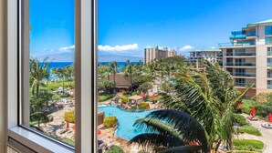Ein Resort mit Swimmingpool, Palmen und Blick auf den Ozean.