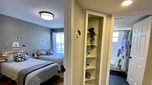 A bedroom with two beds, a wardrobe, and a small hallway. - Fully Remodeled  stylish 3/2 condo, close to the parks (kissimmee)