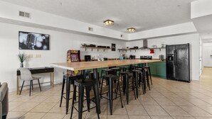 A modern kitchen with a central island, bar stools, and a black refrigerator. - Full house (Myrtle Beach)
