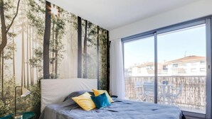 Ein Schlafzimmer mit einem großen Bett, Blick nach draußen und einem Fenster.