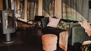 A cozy room with a sofa, ottoman, and a fireplace.