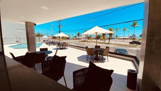 Un espace aménagé au bord de la piscine, avec des sièges et des parasols.