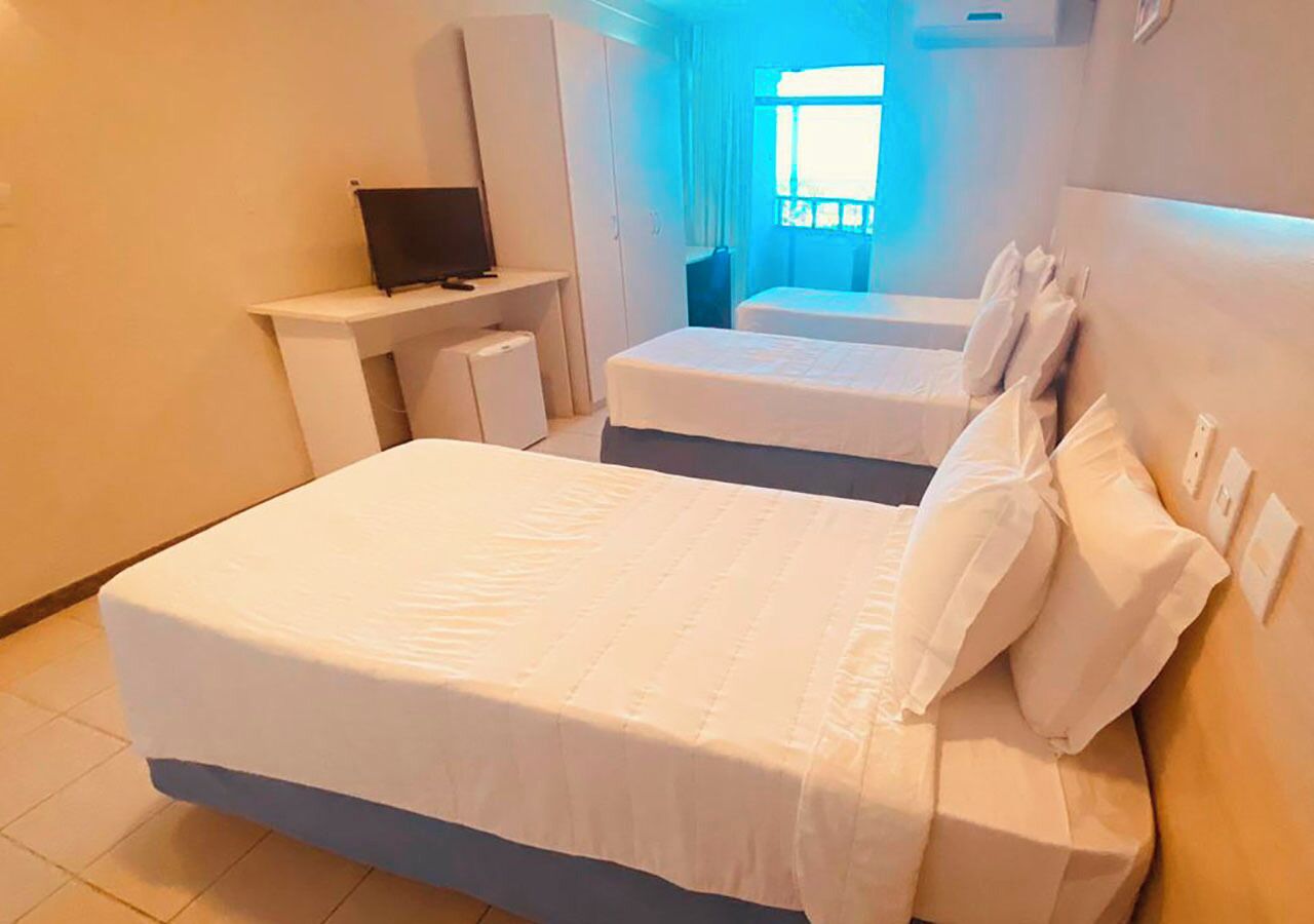 Une chambre d’hôtel avec un lit, un bureau et un téléviseur.