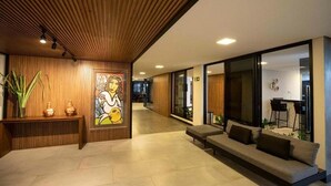 Un hall d’entrée moderne avec un plafond en bois, un comptoir d’accueil, un canapé et de grandes fenêtres.