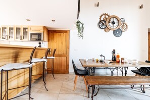 A kitchen with wooden cabinets, a microwave, and a dining table with chairs.